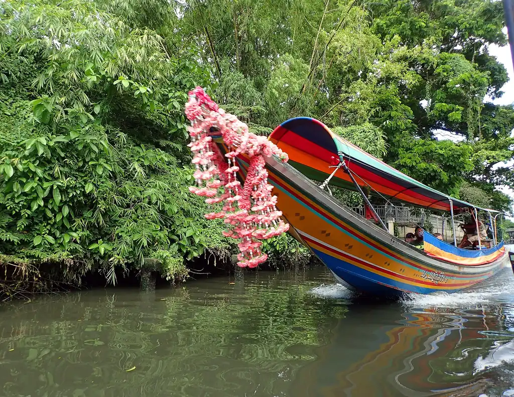 Long-tail boat carrying passengers along a Bangkok khlong canal