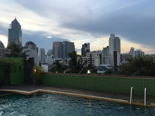 Hotel rooftop swimming pool overlooking Bangkok's Sukhumvit district skyline