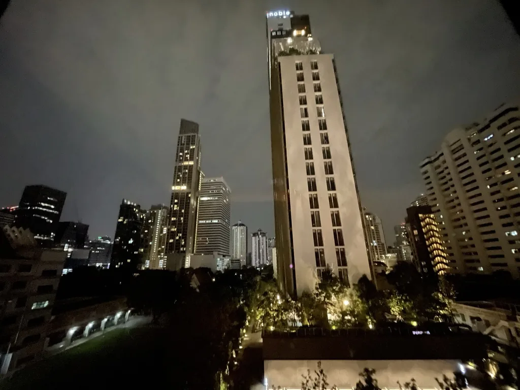 Bangkok city skyline glowing with lights after dark from Asok
