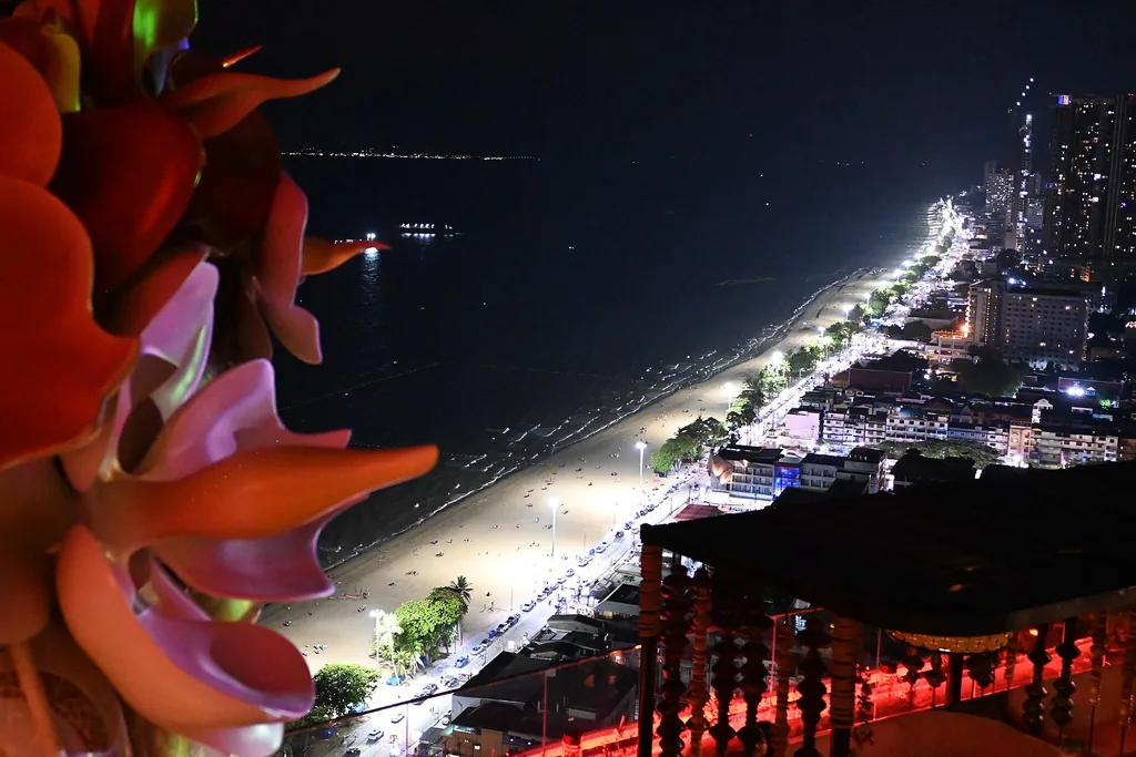 Pattaya coastline and palm-lined beach lit up at night