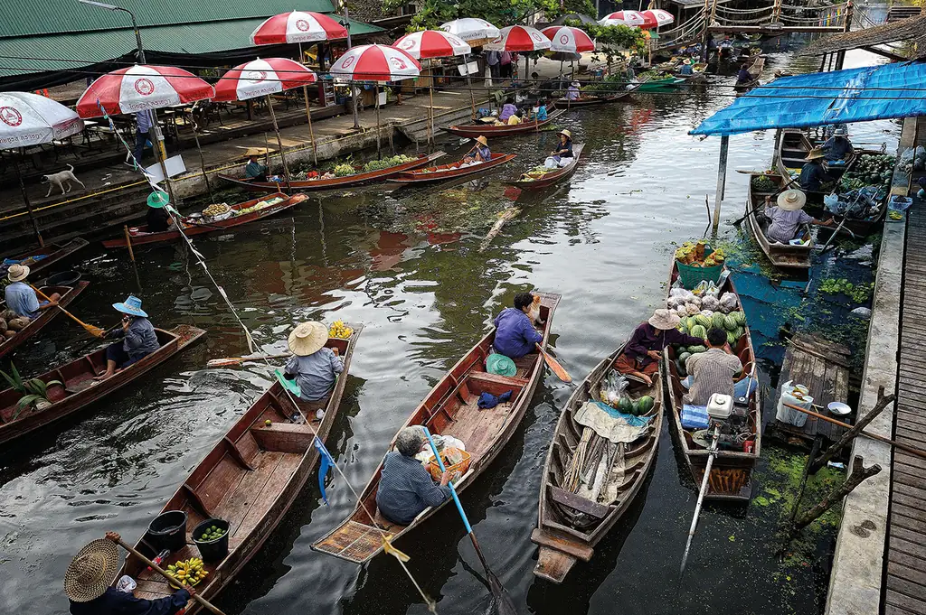 Wooden boats trading along the canal at Tha Kha floating market
