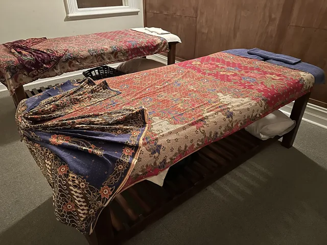 Row of padded massage tables in a traditional Thai massage room