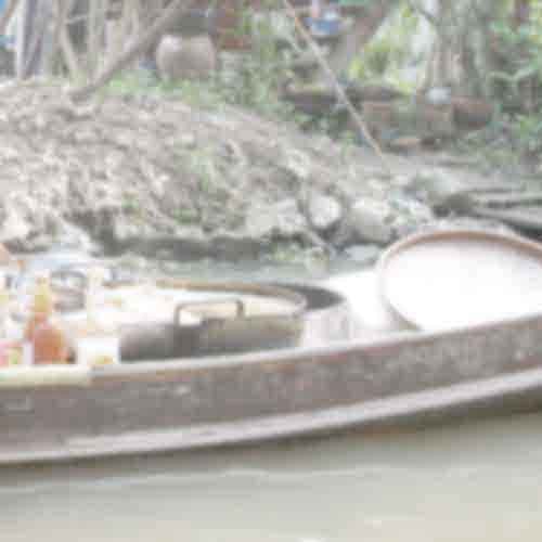 Vendor's boat with cooking pots and utensils on a canal in Bangkok's Floating Market